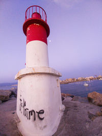 Lighthouse by sea against sky