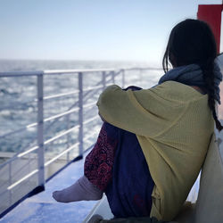 Rear view of woman looking at sea against sky