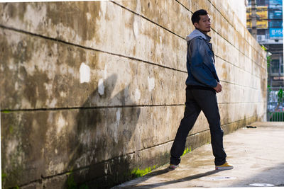 Portrait of man standing by wall