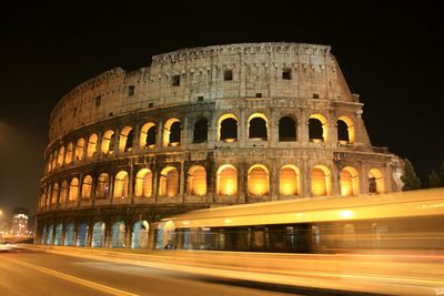 Light trails on street by coliseum at night