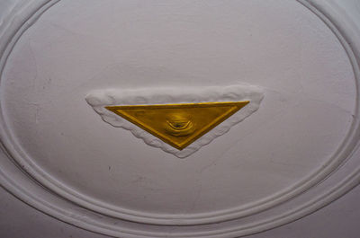 Close-up of yellow mailbox on wall