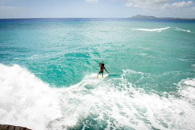 Man surfing in sea against sky