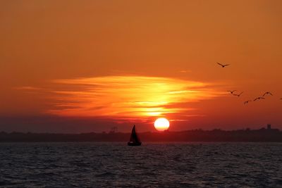 Scenic view of sea against orange sky