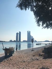 Scenic view of sea by buildings against clear sky