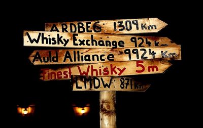 Low angle view of information sign at night