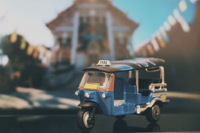 Close-up of toy car against building in city