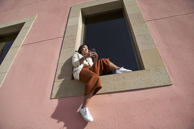 Low angle view of woman on window