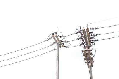 Low angle view of electricity pylon against clear sky