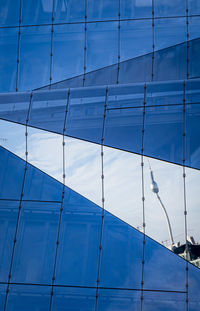 Low angle view of glass building against sky