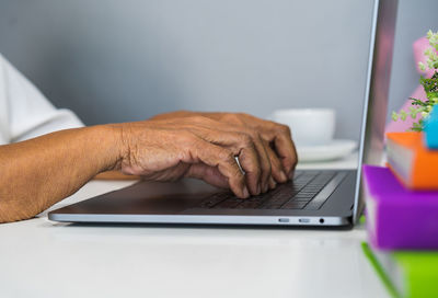 Midsection of man using laptop while working on table