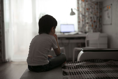 Boy toddler sad on the couch in the real room at home, lifestyles