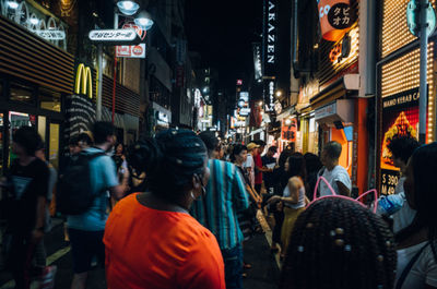 People walking on city street at night