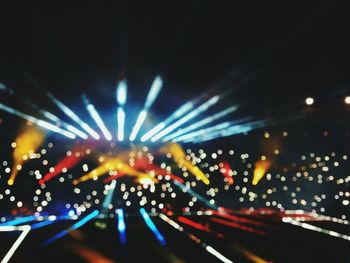 Close-up of illuminated lights against sky at night