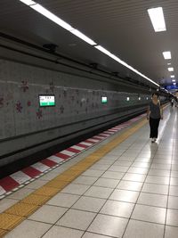 Woman standing on railroad station platform