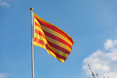 Low angle view of flag against blue sky