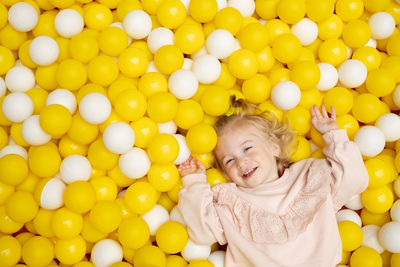 Funny cute little caucaisian blonde baby girl,toddler, smiling kid having fun in ball pool,playing 