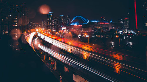 High angle view of illuminated street amidst buildings in city at night