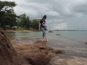 Full length of boy on beach against sky