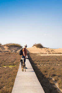 Rear view of man riding bicycle on street