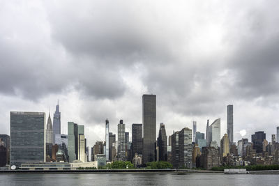 Modern buildings in city against cloudy sky