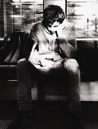 Young man smoking while sitting on laptop