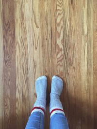 Low section of woman standing on hardwood floor