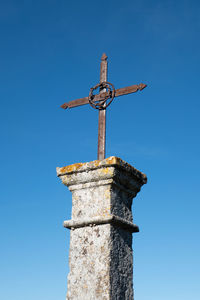 Old christian cross against blue sky in south of france
