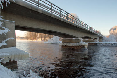 Bridge over river against sky during winter