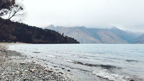 Scenic view of beach and mountains against sky