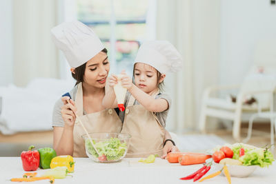 Midsection of woman having food in kitchen
