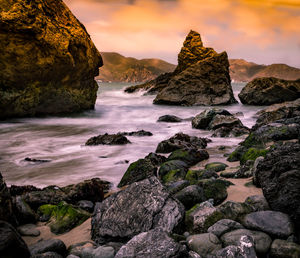 Scenic view of sea against dramatic sky during sunset