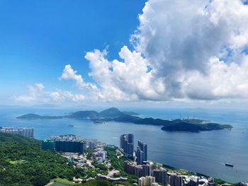 High angle view of city by sea against sky