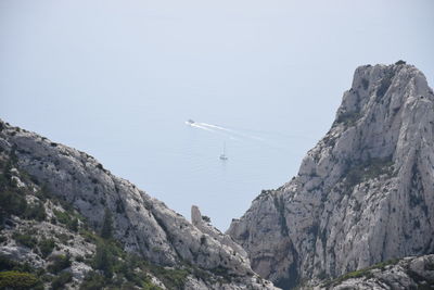 Scenic view of sea and mountains against clear sky