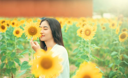 Close-up of woman standing on sunflower