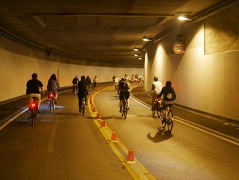 People riding bicycle on road at night