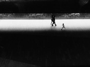 Silhouette people walking on footpath