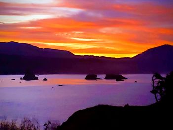 Scenic view of silhouette mountains against romantic sky at sunset