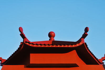 Low angle view of red building against clear blue sky