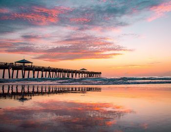 Pier on sea at sunset