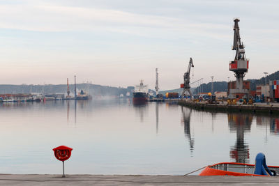 Boats moored at harbor against sky