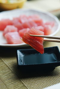 Close-up of meat on chopsticks at table