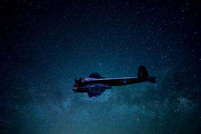 Low angle view of airplane against sky at night