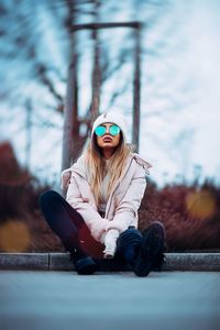 Young woman wearing sunglasses sitting outdoors