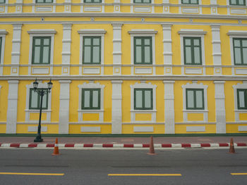 View of yellow building by road