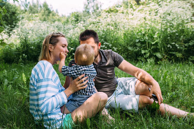 Mom, dad and little son spend time together in the summer outdoors