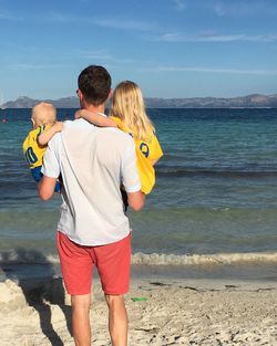 Rear view of man and woman standing on beach