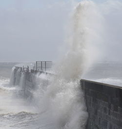 Waves splashing on sea against sky