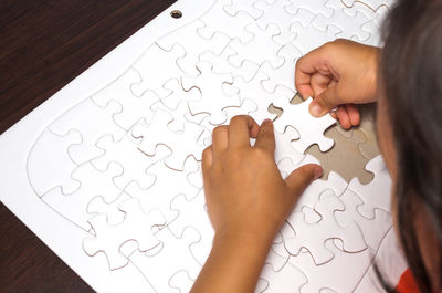 High angle view of woman hand on table