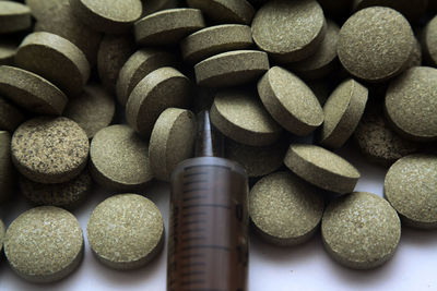 Close-up of pills and syringe on table