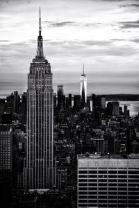 Buildings in city against cloudy sky